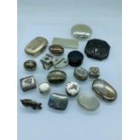 A large selection of silver pill boxes.