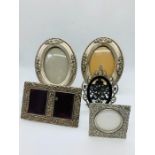 A selection of various sizes of white metal picture frames