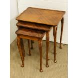 A nest of three tables with elegant cabriole legs with carved thistle design to each leg