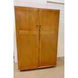 A Ercol single wardrobe with double door and internal drawers and hanging rail with keys