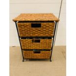 A set of three wicker and metal drawers