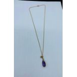 An amethyst and diamond pendant on gold chain.
