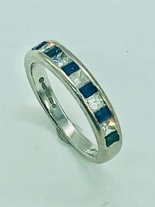 An 18 ct white gold half eternity ring with diamonds and sapphires.