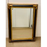 A large black and gilt framed mirror (113cm x 81cm)