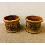 A pair of terracotta garden pots with decorative lemon branches to the side