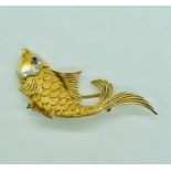 A vintage 18 ct gold brooch in the form of a fish with diamonds and a ruby eye.
