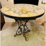 A round cast iron mosaic tiled garden table