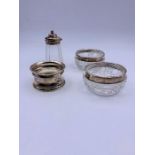 A pair of hallmarked silver rimmed salts, a napkin ring and silver topped glass salt.