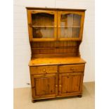 A two door pine dresser with glazed doors to top