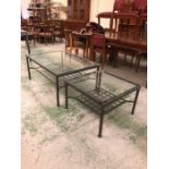 A large metal rectangular coffee table with lower grid shelf and glass top with matching square side