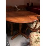 A round country style pine dining/kitchen table with four matching spindle back chairs