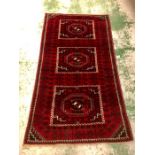 A hand knotted deep red Iranian rug (approx. 137cm x 240cm)