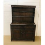 An oak dresser with carved detailing to drawers, doors and edges (H180cm D48cm W125cm)