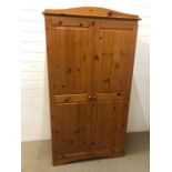 A modern pine wardrobe with hanging rail and upper shelf