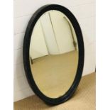 A large heavy oak framed oval mirror with a egg and dart decoration (81cm x 56cm)
