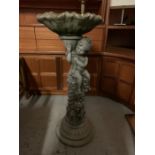 A weathered stone/terracotta garden bird bath