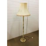 An onyx floor standing lamp base with cream fringed shade