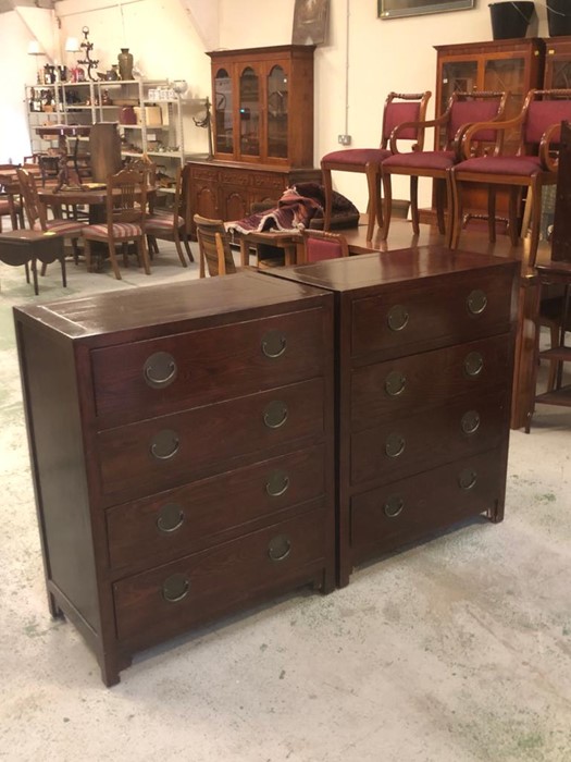 A matching pair of Chinese style chest of drawers to include four drawers and dark bronze coloured