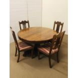 An oak tilt top breakfast table on a octagonal baluster column with a tripartite base and scrolled