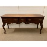 A Mahogany sideboard with three drawers and brass handles.