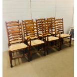 A Set of six pine ladder back rush seated chairs and two carvers