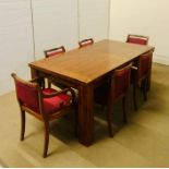 A large solid extendable hardwood table with six matching chairs to include two carvers with a