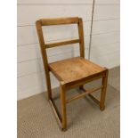 A wooden child's school chair with stretcher to elgs