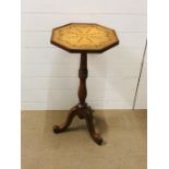 A tall occasional table with a pretty decorative top