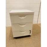 A white metal three drawer lockable filing cabinet