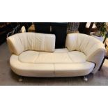 A white leather sofa which the back moves to the sides