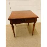 A small square occasional table with drawer to centre