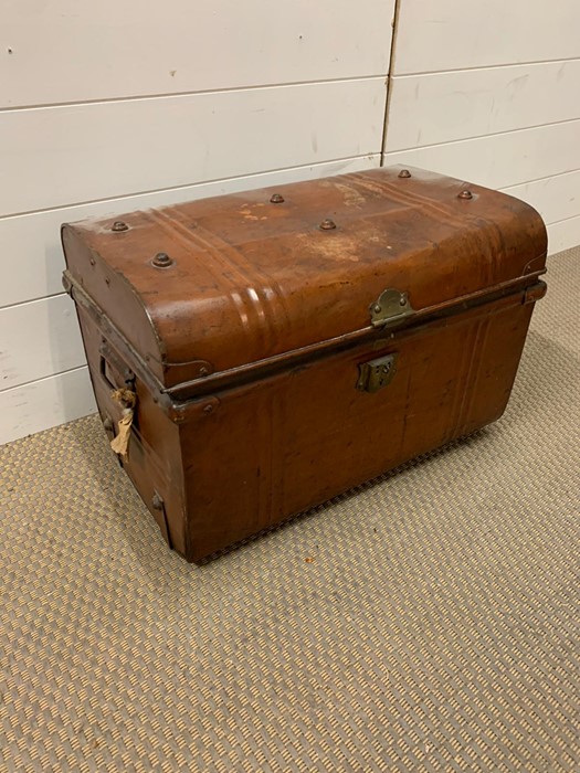 A metal trunk with stud work to lid