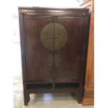A large Chinese style wardrobe in the style of a Chinese Wedding cabinet with dark bronze coloured