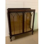 A glazed mahogany two door display unit on cabriole legs