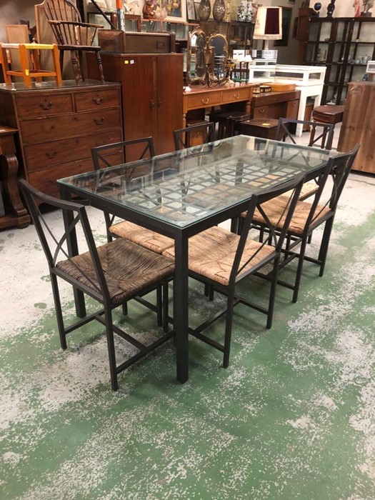 A metal dining table with lower grid shelf and glass top with six matching dining chairs with rushed