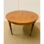 A pine round kitchen table with two leaves