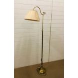 A brass floor standing reading lamp with pleated lamp shade