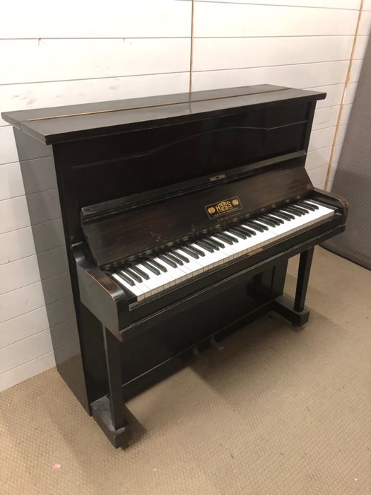 A striking small upright piano in a dark brown gloss wood made by Hicks of New Kent Road (H117cm