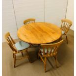 A round pine dining table with four chairs