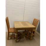 A square extendable pine farmhouse kitchen table and two teak chairs 76 cm H x 90 cm W x 93 cm (