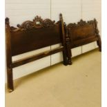 A carved wooden double bed complete with slats