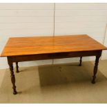 A dining table on turned legs with central drawer