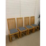 A set of four pine ladder back chairs with blue fabric seats