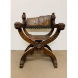 A carved X framed oak folding chair with leather seat and back rest