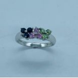 14 k White gold ring set with three sets of gems in pink, blue and green. Size M.