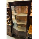 A lovely Edwardian serpentine glass fronted mahogany display cabinet on elegant legs with original