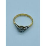 An 18ct gold ring with a single diamond and diamond shoulders size P