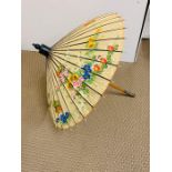 An oriental parasol with painted flowers to the outside