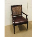 A lovely mahogany open arm chair with leather seat and cane back