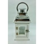 A small white painted wood and chrome lantern with silver candle